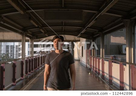Man is walking on the bridge in the city. 112442896