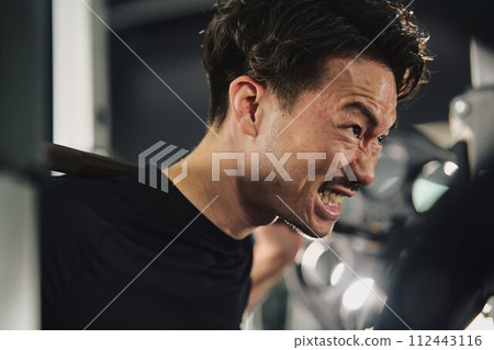 A man doing machine training at the gym 112443116