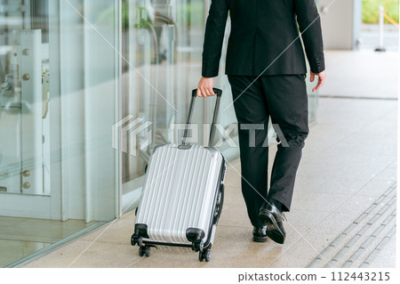 A man walking with a suitcase/carry case/trunk (business trip/overseas assignment) 112443215