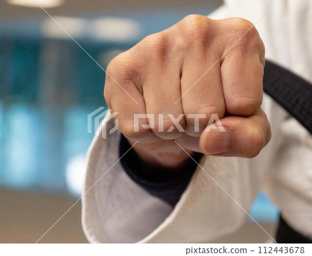 Fist of a martial artist wearing a gi Fist of a martial artist wearing a gi 112443678
