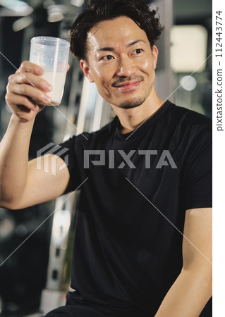 Young man drinking protein at training gym Young man drinking protein at training gym 112443774