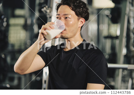 Young man drinking protein at training gym 112443786
