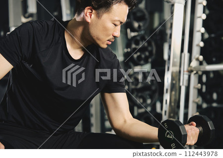Man doing dumbbell training at the gym 112443978