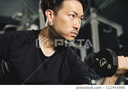 Man doing dumbbell training at the gym 112443990