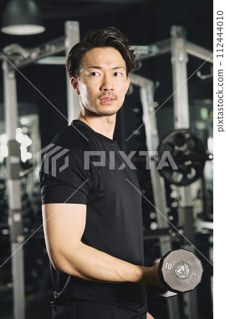 Man doing dumbbell training at the gym Man doing dumbbell training at the gym 112444010