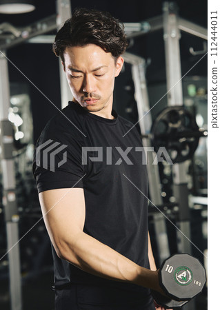 Man doing dumbbell training at the gym Man doing dumbbell training at the gym 112444011