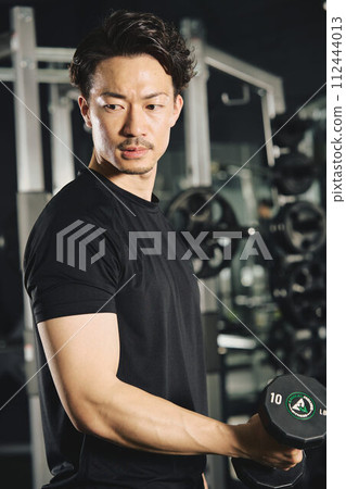 Man doing dumbbell training at the gym Man doing dumbbell training at the gym 112444013