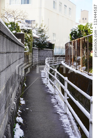 沿著積雪覆蓋的灌溉渠的道路 112444587