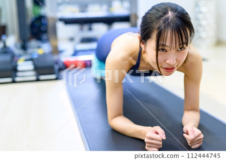 Young woman training her body at a personal gym, muscle training girl, push-ups, plank Young woman training her body at a personal gym, muscle training girl, push-ups, plank 112444745
