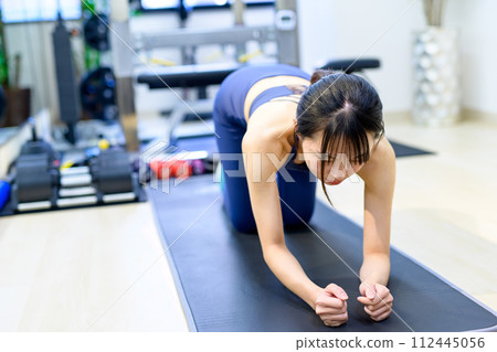 Young woman training her body at a personal gym, muscle training girl, push-ups, plank 112445056