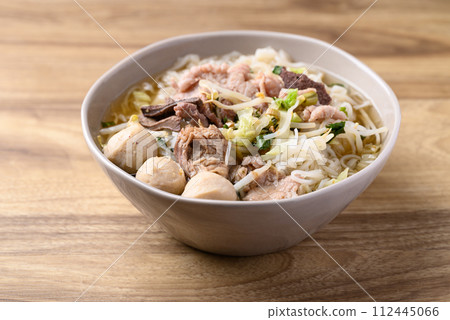 Rice noodles soup with pork in bowl on wooden background, Thai noodles soup Rice noodles soup with pork in bowl on wooden background, Thai noodles soup 112445066