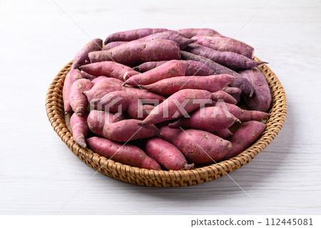 Organic raw sweet potatoes in basket on white table 112445081