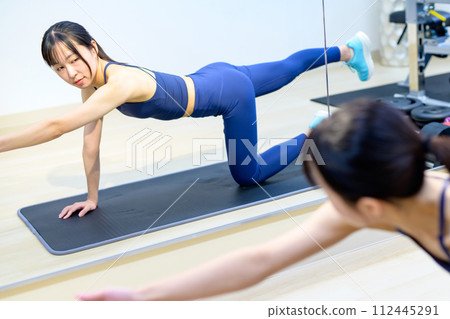 年輕女子在私人健身房訓練身體，肌肉訓練女孩，伏地挺身，單手木板，修剪 112445291