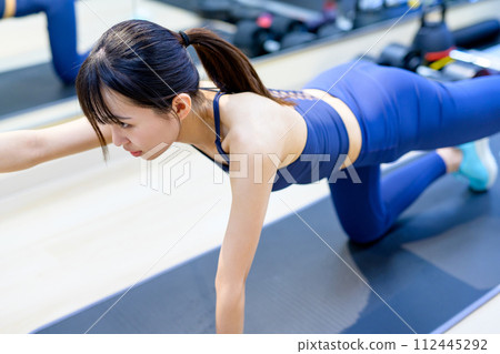 年輕女子在私人健身房訓練身體、肌肉訓練女孩、伏地挺身、單手平板支撐 112445292