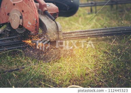 Construction Worker hands using Welding machinery iron metal sparking. Men hands wear protective glove Hot flame metal work cutting fire iron workshop. Locksmith use Welding machine cut metal process 112445323