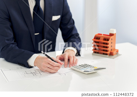 Businessman calculating the floor plan of an apartment 112448372