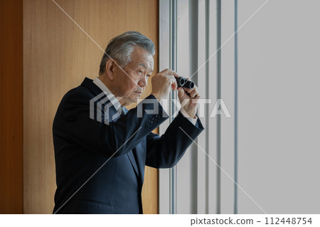 高級商人用雙筒望遠鏡觀察下面的建築物 112448754
