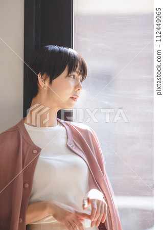 A young woman looking out the window 112449965