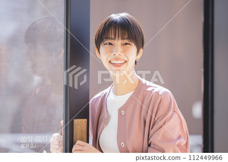 A woman who opens a door 112449966