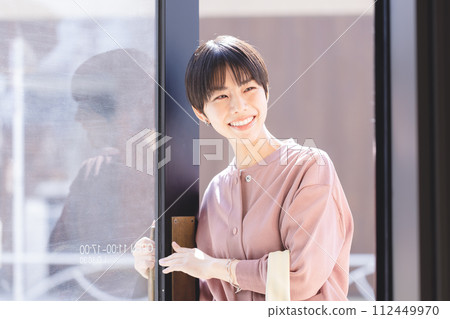A woman who opens a door 112449970
