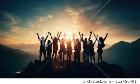 Peak triumph: silhouettes a top mountain, joyous group celebrates team success , embodying shared victories, harmonious collaboration, euphoria of collective achievement in nature's majestic embrace. 112450491