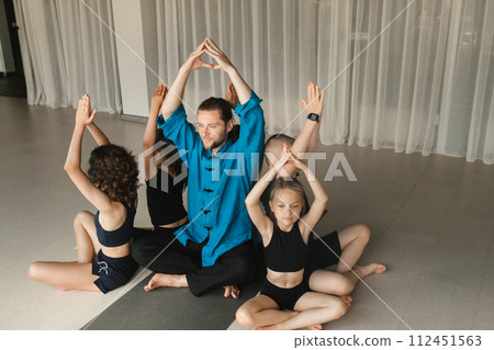 The coach's team and the children are sitting together in the fitness room The coach's team and the children are sitting together in the fitness room 112451563