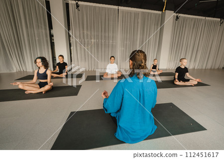 Children do yoga in the gym under the guidance of an instructor. Children's gymnastics 112451617