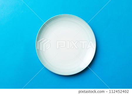 Top view of isolated of colored background empty round blue plate for food. Empty dish with space for your design Top view of isolated of colored background empty round blue plate for food. Empty dish with space for your design 112452402