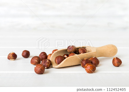 Hazelnut heap in spoon on wooden table, top view Hazelnut heap in spoon on wooden table, top view 112452405