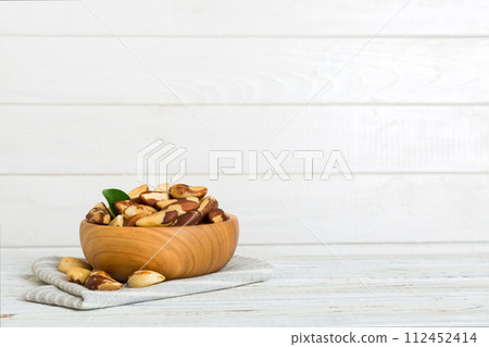 Fresh healthy Brazil nuts in bowl on colored table background. Top view Healthy eating bertholletia concept. Super foods Fresh healthy Brazil nuts in bowl on colored table background. Top view Healthy eating bertholletia concept. Super foods 112452414