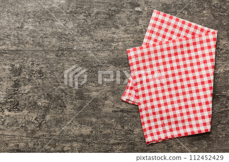 top view with red empty kitchen napkin isolated on table background. Folded cloth for mockup with copy space, Flat lay. Minimal style top view with red empty kitchen napkin isolated on table background. Folded cloth for mockup with copy space, Flat lay. Minimal style 112452429