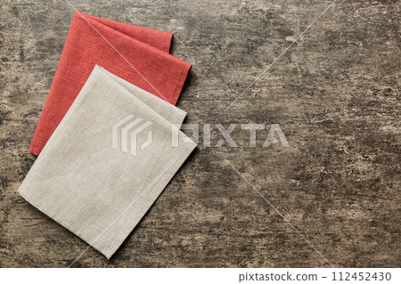 top view with gray kitchen napkin isolated on table background. Folded cloth for mockup with copy space, Flat lay. Minimal style top view with gray kitchen napkin isolated on table background. Folded cloth for mockup with copy space, Flat lay. Minimal style 112452430