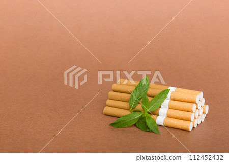 Menthol cigarettes and fresh mint leaves on colored background, Many cigarettes stacked together top view flat lay 112452432