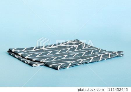 top view with blue kitchen napkin isolated on table background. Folded cloth for mockup with copy space, Flat lay. Minimal style 112452443