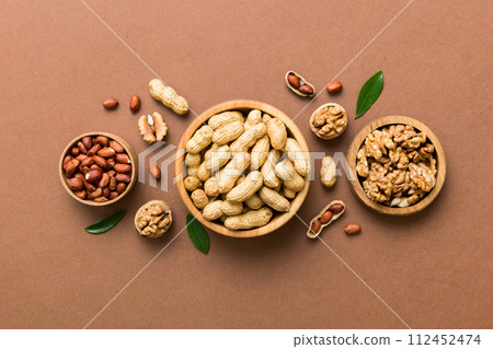 Walnut kernel halves, in a wooden bowl. Close-up, from above on colored background. Healthy eating Walnut concept. Super foods with copy space 112452474