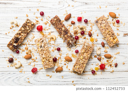 Various granola bars on table background. Cereal granola bars. Superfood breakfast bars with oats, nuts and berries, close up. Superfood concept 112452733