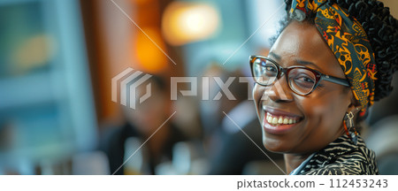 A woman with glasses and a colorful head scarf is smiling A woman with glasses and a colorful head scarf is smiling 112453243