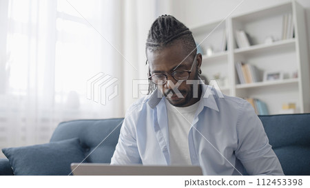 African American businessman working on laptop at home, freelancer, IT specialist 112453398