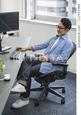 A man in his 50s working at a desk A man in his 50s working at a desk 112453966
