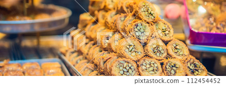BANNER, LONG FORMAT Traditional oriental sweet pastry cookies, nuts, dried fruits, pastilles, marmalade, Turkish desert with sugar, honey and pistachio, in display at a street food market 112454452