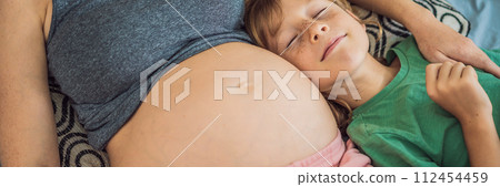 BANNER, LONG FORMAT Young beautiful pregnant woman and eldest son. The cute boy leaned his ear against his mother's belly. Expecting a baby in the family concept. Preparing an older child for a BANNER, LONG FORMAT Young beautiful pregnant woman and eldest son. The cute boy leaned his ear against his mother's belly. Expecting a baby in the family concept. Preparing an older child for a 112454459