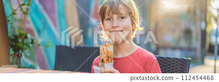 Boy eating street food in Istanbul. Balik ekmek - fish in a bread, traditional Turkish fast food. Istanbul, Turkey BANNER, LONG FORMAT Boy eating street food in Istanbul. Balik ekmek - fish in a bread, traditional Turkish fast food. Istanbul, Turkey BANNER, LONG FORMAT 112454468