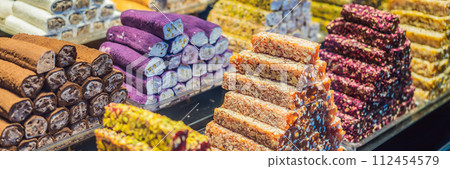 BANNER, LONG FORMAT Traditional oriental sweet pastry cookies, nuts, dried fruits, pastilles, marmalade, Turkish desert with sugar, honey and pistachio, in display at a street food market BANNER, LONG FORMAT Traditional oriental sweet pastry cookies, nuts, dried fruits, pastilles, marmalade, Turkish desert with sugar, honey and pistachio, in display at a street food market 112454579