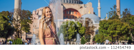 BANNER, LONG FORMAT Woman enjoy beautiful view on Hagia Sophia Cathedral, famous islamic Landmark mosque, Travel to Istanbul, Turkey. Sunny day architecture and Hagia Sophia Museum, in Eminonu 112454749