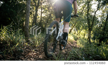Mountain biking on spring forest trail Mountain biking on spring forest trail 112454860