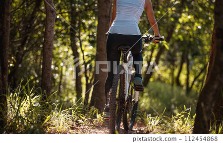 Mountain biking on spring forest trail Mountain biking on spring forest trail 112454868