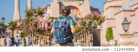 BANNER, LONG FORMAT Man enjoy beautiful view on Hagia Sophia Cathedral, famous islamic Landmark mosque, Travel to Istanbul, Turkey. Sunny day architecture and Hagia Sophia Museum, in Eminonu, istanbul 112454988