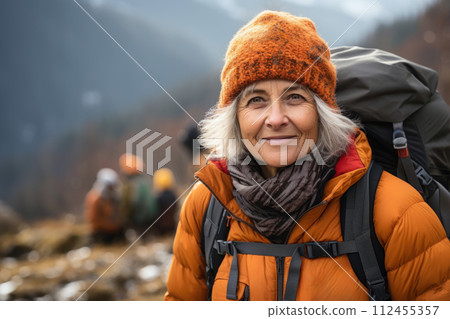 senior woman with backpack hiking in the mountains 112455357