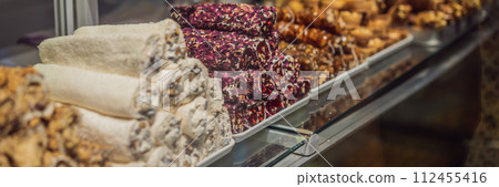 BANNER, LONG FORMAT Traditional oriental sweet pastry cookies, nuts, dried fruits, pastilles, marmalade, Turkish desert with sugar, honey and pistachio, in display at a street food market BANNER, LONG FORMAT Traditional oriental sweet pastry cookies, nuts, dried fruits, pastilles, marmalade, Turkish desert with sugar, honey and pistachio, in display at a street food market 112455416