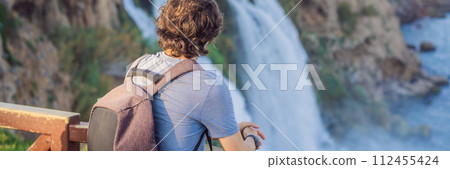 BANNER, LONG FORMAT Man tourist on the background of Duden waterfall in Antalya. Famous places of Turkey. Lower Duden Falls drop off a rocky cliff falling from about 40 m into the Mediterranean Sea in BANNER, LONG FORMAT Man tourist on the background of Duden waterfall in Antalya. Famous places of Turkey. Lower Duden Falls drop off a rocky cliff falling from about 40 m into the Mediterranean Sea in 112455424